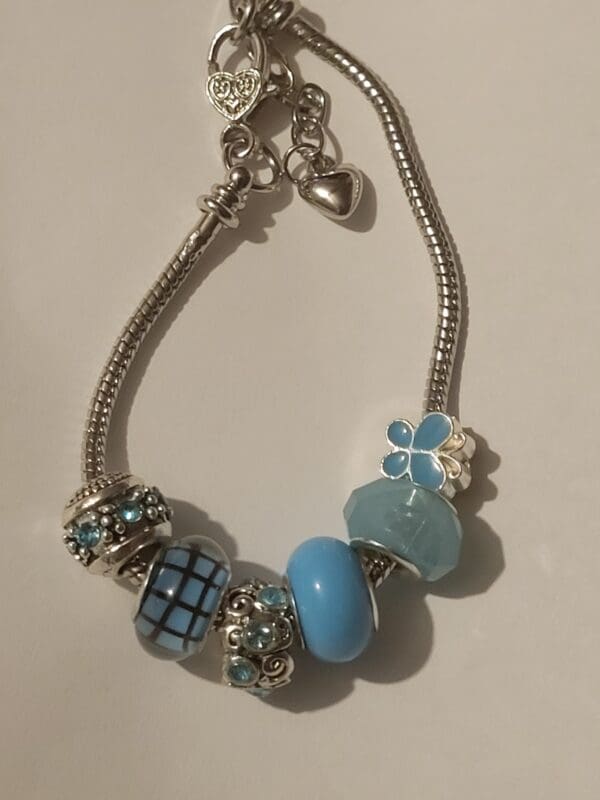 A bracelet with blue beads and charms on it.