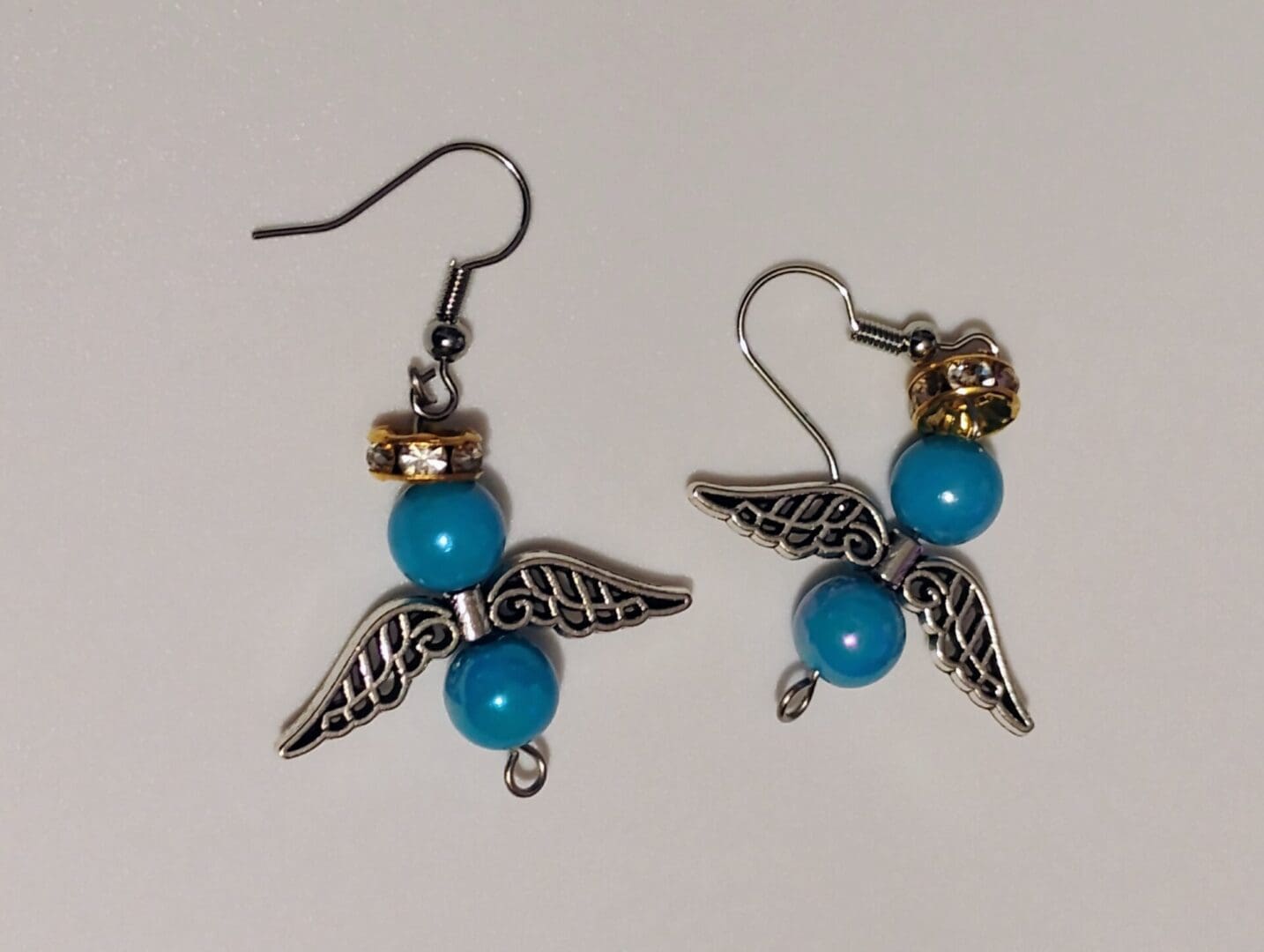 Silver angel wing earrings with blue beads.
