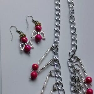 Handcrafted jewelry featuring red beads and silver chains.